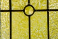 Etched glass window backlit with bright yellow autumn color shinning through