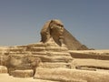 Eternal Stone Sphinx. The ancient Egyptian sphinx of yellow stone on the background of the mighty pyramids.