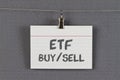 ETF buy and sell written on an index card