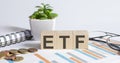 ETF word on wood blocks concept with chart, coins, notebook and glasses Royalty Free Stock Photo