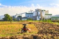 Ethanol industrial refinery with farm tractors in the foreground