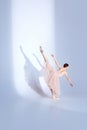 Ethereal Ballet. Body-Size Portrait of sensitively posed ballerina adorned in white tutu, dances against white studio Royalty Free Stock Photo