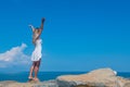 Ethereal Beauty: A Girl in a White Dress on the Stones by the Sea