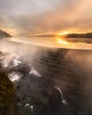 Ethereal moody sunrise with low fog and steam being illuminated over a lake and waterfall. Croton Gorge, NY Royalty Free Stock Photo