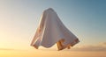 Ethereal white cape levitating gracefully against a pastel sky backdrop Royalty Free Stock Photo