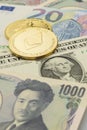 Ethereum and Bitcoin coins laid on top of Yen, US Dollar and Euro banknotes Royalty Free Stock Photo