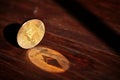 Ethereum blockchain cryptocurrency with its shadow on wooden table, close-up, selective focus