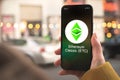 Ethereum Classic ETC cryptocurrency symbol, logo. Business and financial concept. Hand with smartphone, screen with