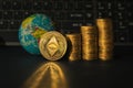 The ethereum coin against the background of stacks of coins and a financial chart