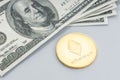 Ethereum coin and a pile of US dollar banknotes