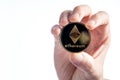 Man holding an Ether Ethereum coin on a white background