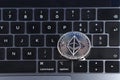 Ethereum cryptocurrency crypto currency. Silver Ethereum coin with gold Ethereum symbol on a laptop keyboard next to the Enter Royalty Free Stock Photo