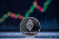 Ethereum physical coin symbol on laptop with uptrend price graph background