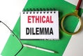 ETHICAL DILEMMA text on notebook on green paper