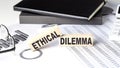ETHICAL DILEMMA - text on a wooden block with chart and notebook