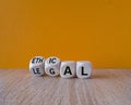 Ethical or legal symbol. Businessman hand turns wooden cubes and changes the word legal to ethical on a beautiful wooden t Royalty Free Stock Photo