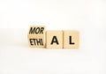 Ethical or moral symbol. Businessman turns wooden cubes and changes the word Ethical to Moral on a Beautiful white table white Royalty Free Stock Photo