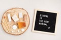 Ethical is the new normal. Black letter board with set of eco friendly personal hygiene items on wooden platform, on