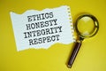 Ethics, Honesty, Integrity, Respect text on paper torn with magnifying glass top view on yellow background Royalty Free Stock Photo