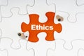 ETHICS inscription written on jigsaw puzzle and businessman miniature