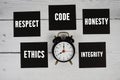 Ethics, Respect, Code, Honesty, Integrity text written on sticky note and alarm clock flat lay on wooden background Royalty Free Stock Photo