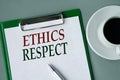 ETHICS RESPECT - words on a white sheet on a gray background with a pen and a cup of coffee