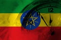 Ethiopia, Ethiopian flag with clock close to midnight in the background. Happy New Year concept