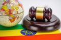 Ethiopia flag and Judge hammer with globe world map. Law and justice court. Royalty Free Stock Photo