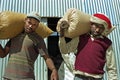 Ethiopian farmers lugging sacks of grain