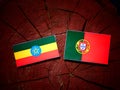 Ethiopian flag with Portuguese flag on a tree stump isolated
