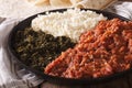 Ethiopian kitfo with herbs and cheese ayibe and injera close-up. horizontal