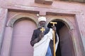 Ethiopian man in traditional clothes holding a stick and hand cross in his hand, Ethiopia