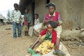 Ethiopian teenager braid her sisters hair