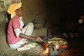 Ethiopian woman baking grain on wood fire