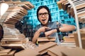 Ethnic asian girl surrounded by books in library at night. Student is looking at watch. Royalty Free Stock Photo