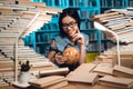 Ethnic asian girl surrounded by books in library at night. Student is using globe. Royalty Free Stock Photo