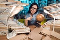 Ethnic asian girl surrounded by books in library at night. Student is using globe. Royalty Free Stock Photo