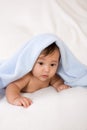 Ethnic baby boy lying down under blanket peekaboo Royalty Free Stock Photo