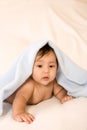 Ethnic baby boy lying under blanket (peekaboo) Royalty Free Stock Photo