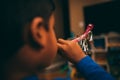 Ethnic boy blows red party blowers in living room