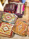 Ethnic carpet, ornamental folk bags, many ornate pillows with embroidery in asian shop, store. Asian market, trade fair in