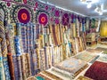 Ethnic carpet, ornamental folk bags, many ornate pillows with embroidery in asian shop, store. Asian market, trade fair