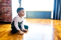 ethnic hispanic curly son sitting on floor warm brown clean safety parquet at home