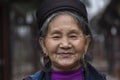 Ethnic Hmong woman wearing traditional attire and jewelry wait for tourists to sell handicrafts on the street in Sapa region, Royalty Free Stock Photo