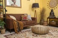 Ethnic living room with brown sofa and yellow wall Royalty Free Stock Photo
