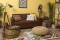 Ethnic living room with brown sofa and yellow wall Royalty Free Stock Photo