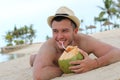Ethnic male drinking a fresh coconut at the beach Royalty Free Stock Photo