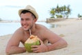 Ethnic male drinking a fresh coconut at the beach Royalty Free Stock Photo