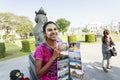 An ethnic minority woman sell postcard in a center park in Yangon