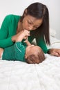 Ethnic mother playing with her baby boy son on bed Royalty Free Stock Photo